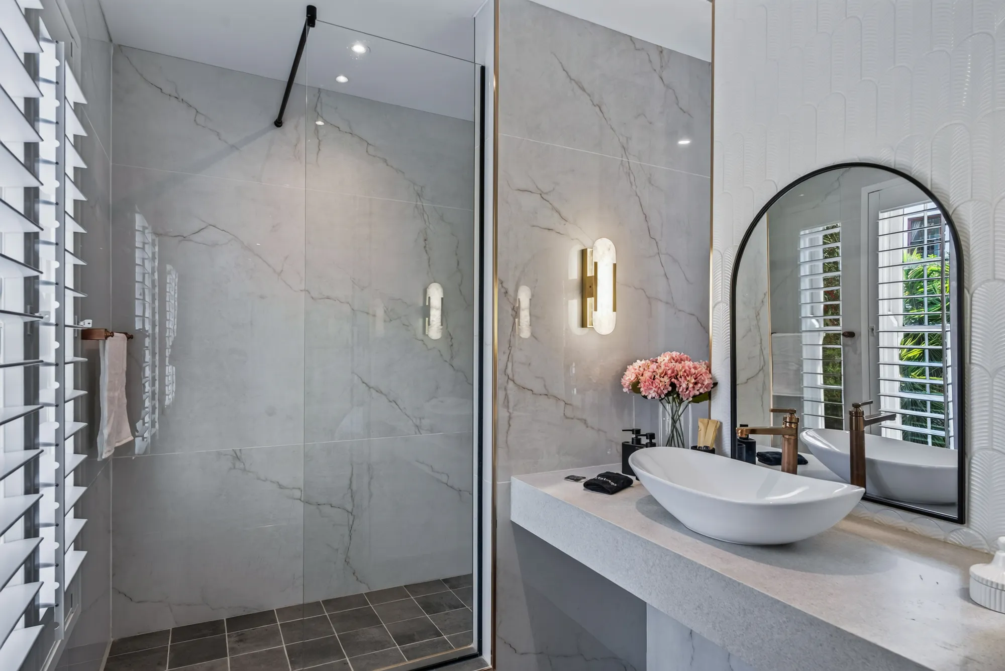 An en-suite bathroom with an arched mirror at Casa Dias