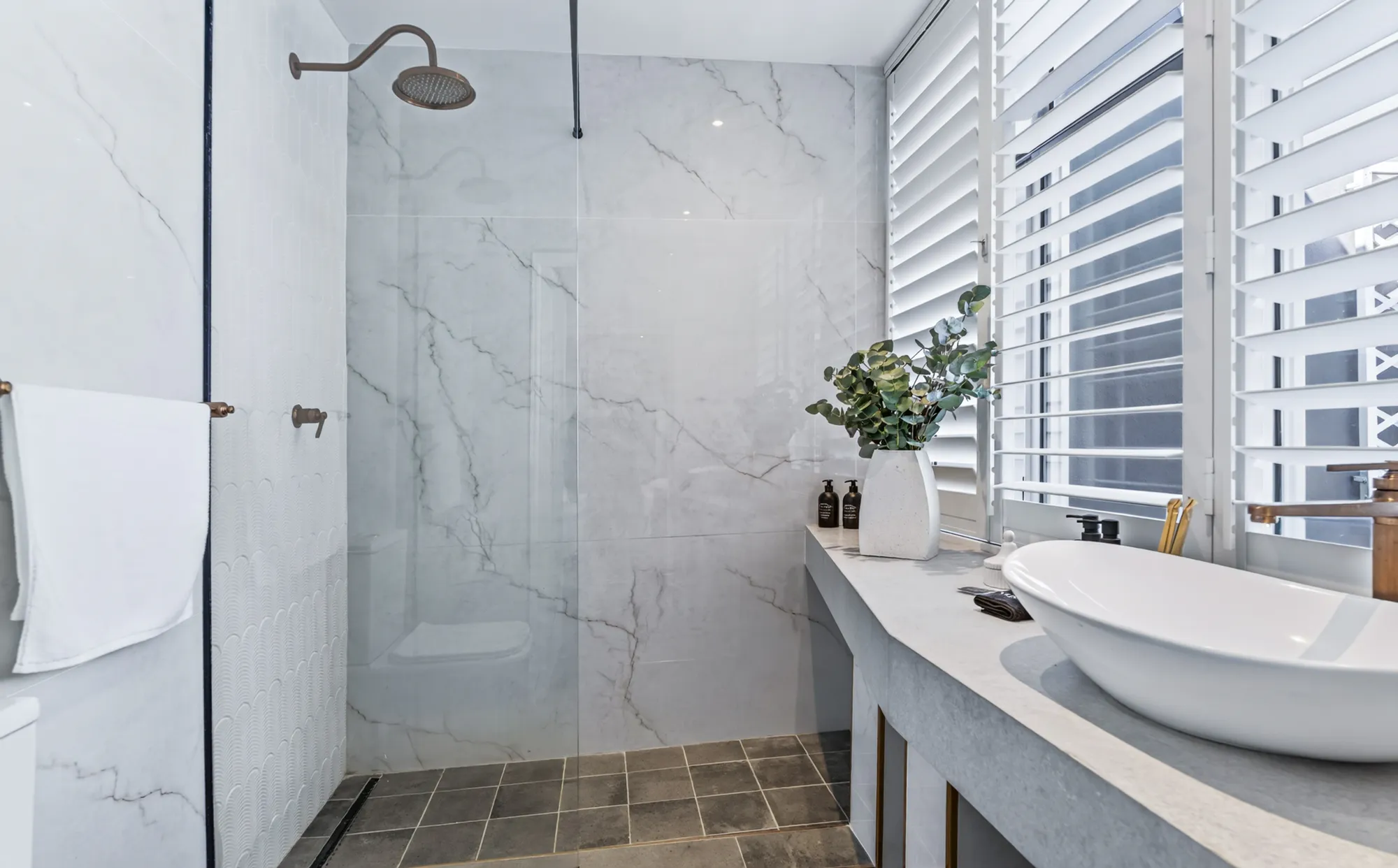 A marble shower room with plantation shutters at Casa Dias