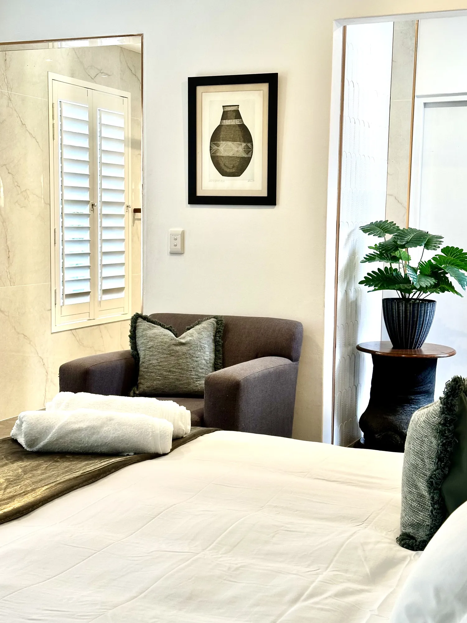 A Casa Dias bedroom with an armchair and en-suite beyond