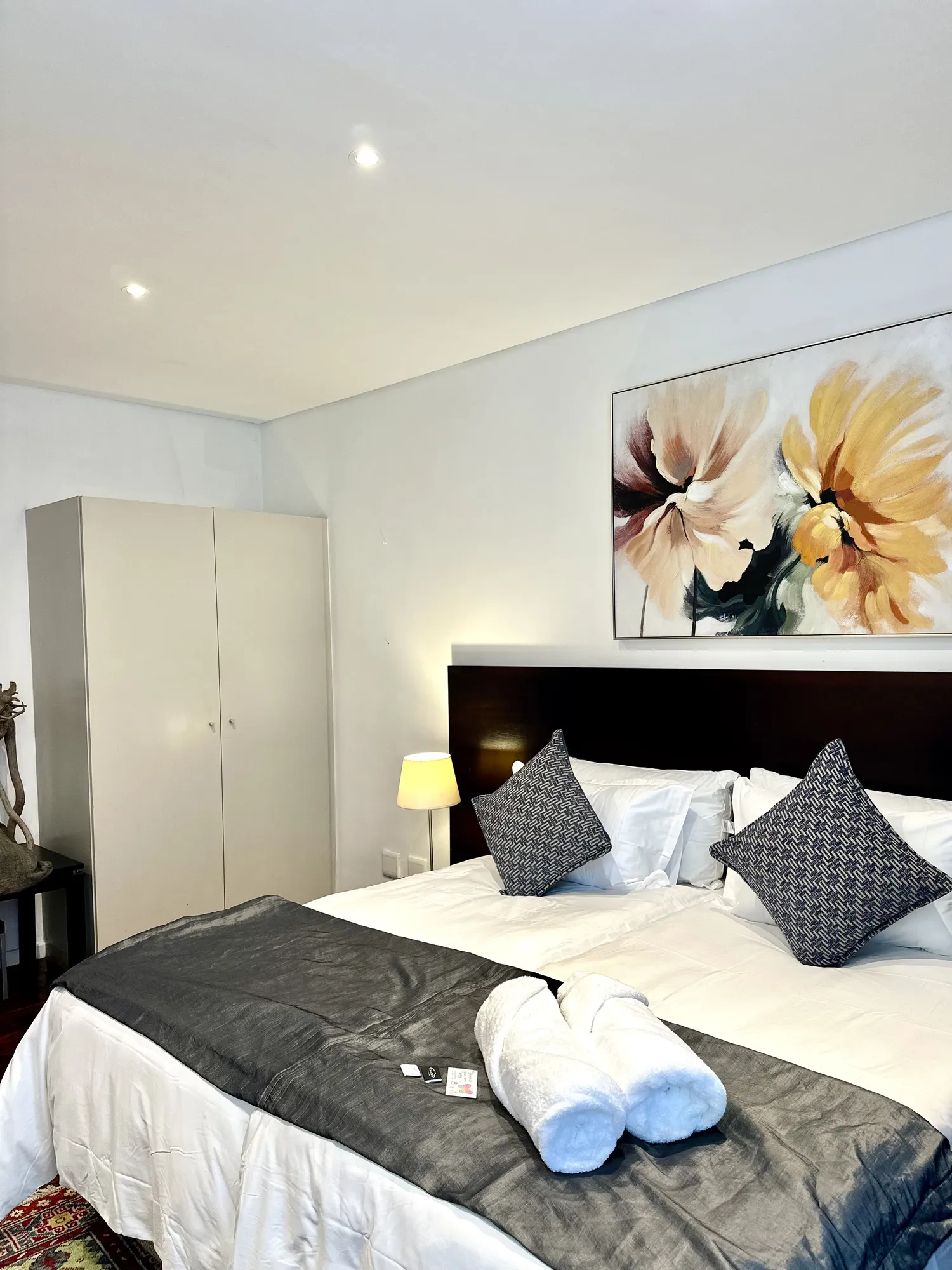 A Casa Dias bedroom with a large floral painting above the bed