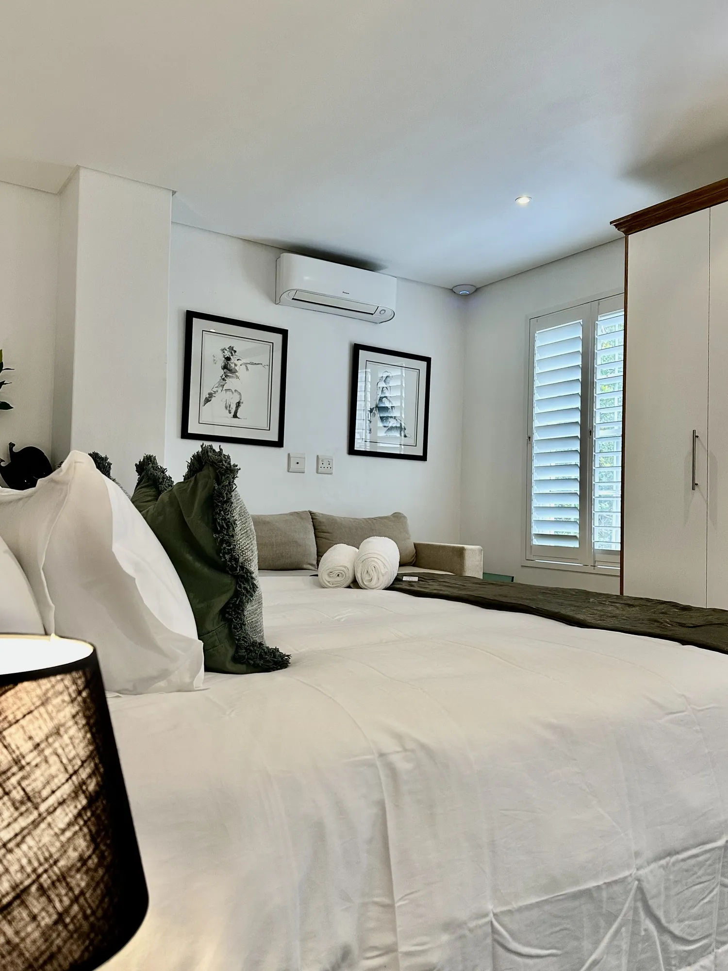 A Casa Dias bedroom with a sofa, shutters, and wardrobe