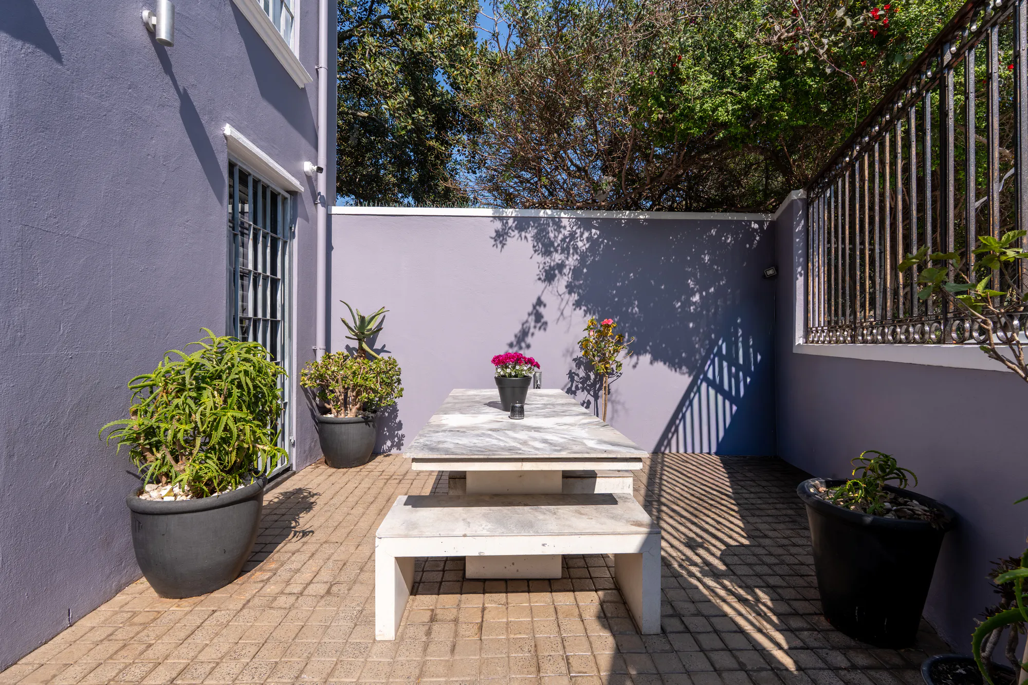 The courtyard at Casa Dias with a picnic table against lilac walls