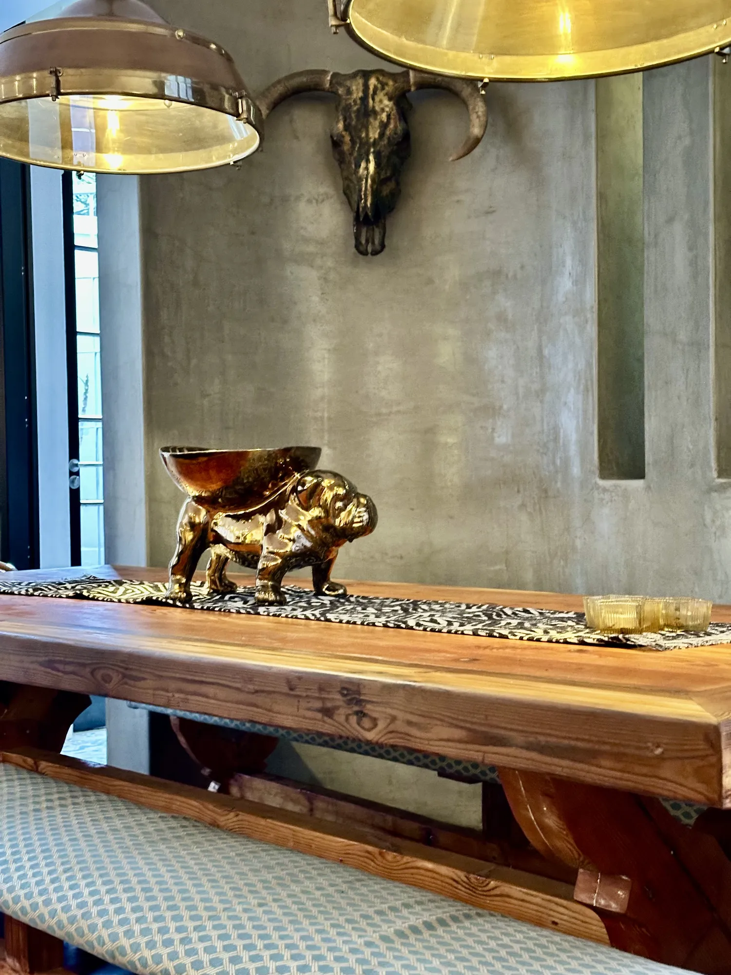 The Casa Dias dining table with a brass centrepiece and upholstered bench