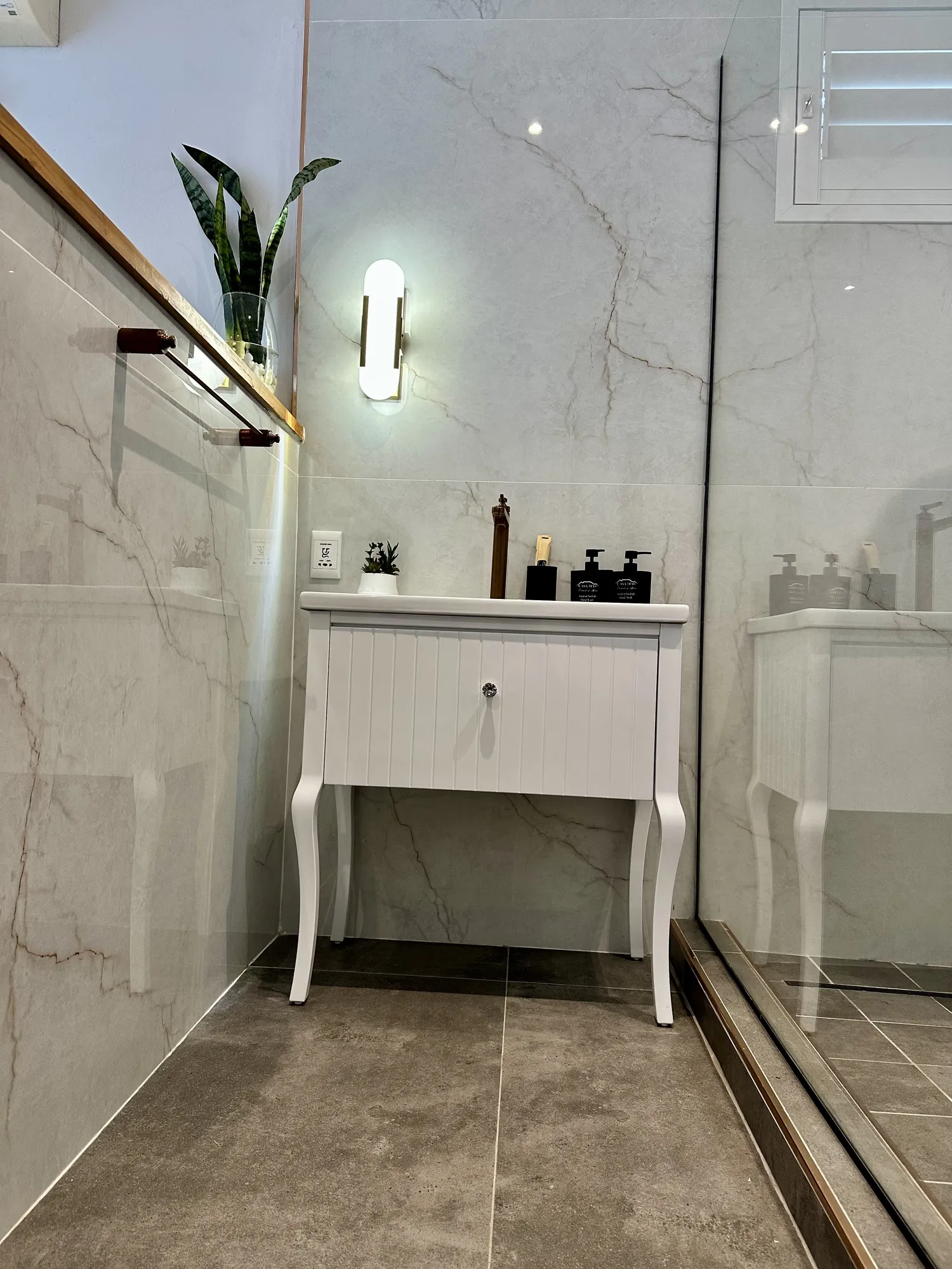 A white vanity in a marble en-suite at Casa Dias
