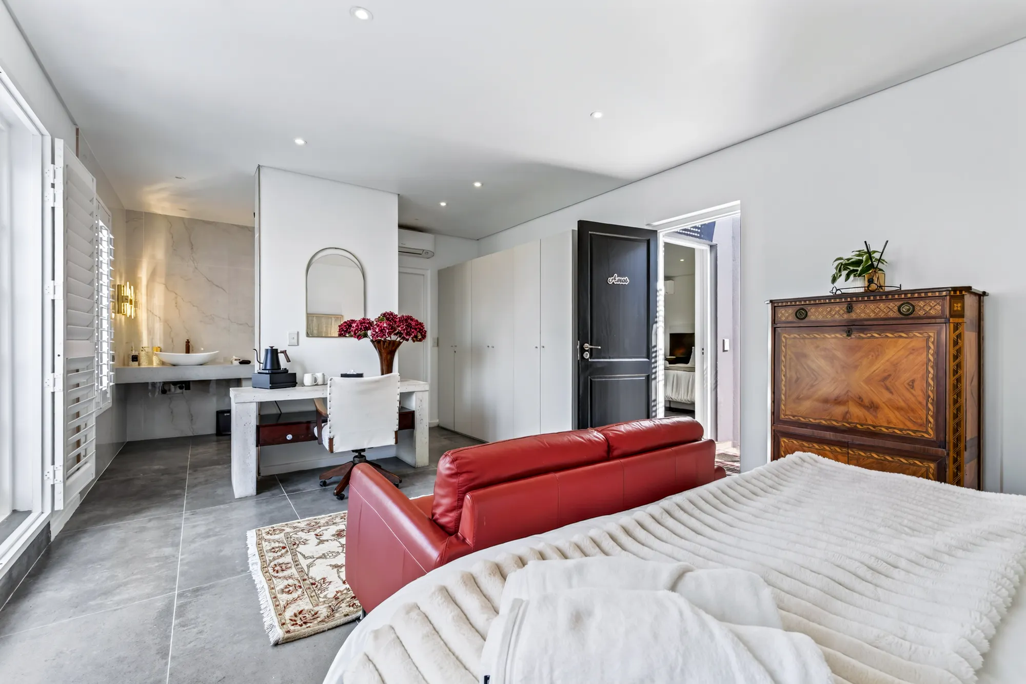 A Casa Dias bedroom with a sitting area, desk, and en-suite beyond
